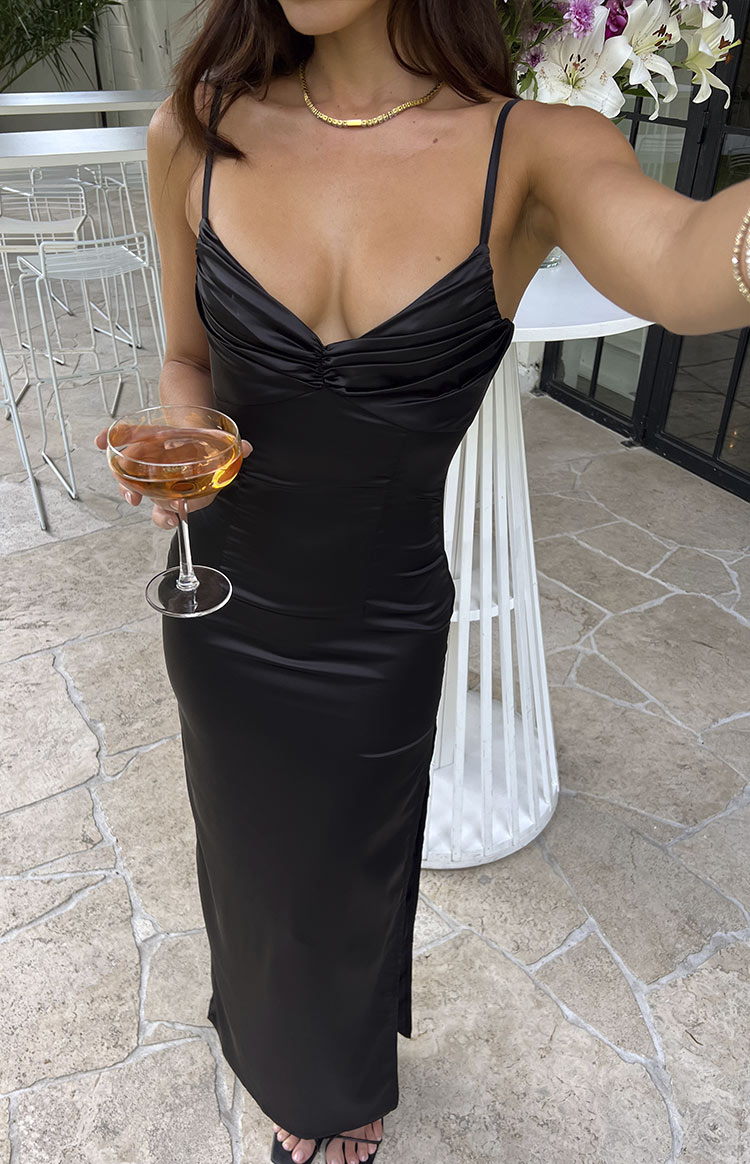 Black satin maxi dress with a ruched sweetheart neckline, fitted bodice, and a long skirt with a side slit