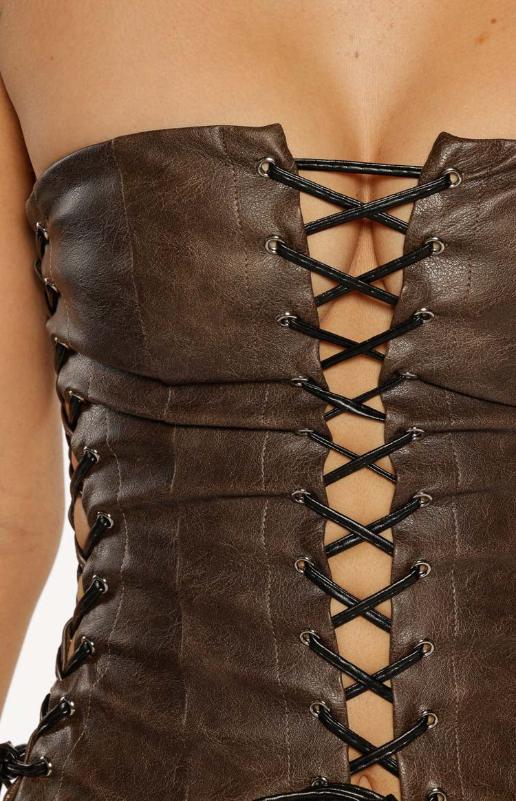 Close-up of the vintage brown PU corset top's front lacing, with black criss-cross laces through silver eyelets