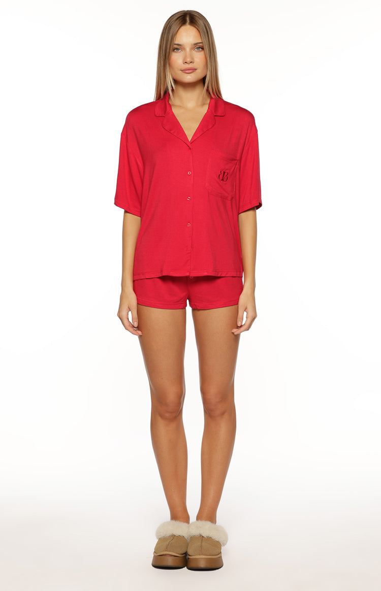 Red mini pajama shorts with an elasticated waist and relaxed fit, worn with a matching short-sleeved top
