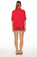 Rear view of the red short sleeve collared pajama top and matching mini pajama shorts