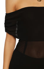 Detail shot of the black sheer off-the-shoulder midi dress showing ruched shoulder and sheer midriff