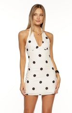 White polka dot mini dress with a halter neckline, deep V-neck, and fitted bodycon silhouette