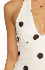 Close-up of the white polka dot halter mini dress showing the V-neckline and gathered bust detail