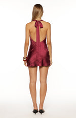 Rear view showing the halter neck tie and low scoop back of a burgundy satin mini dress