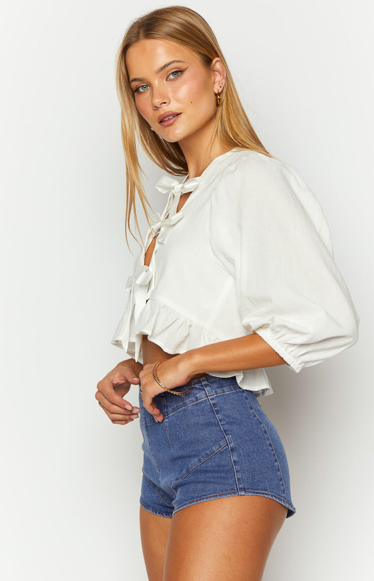 Side view of dark denim micro shorts with a high waist and front seam details