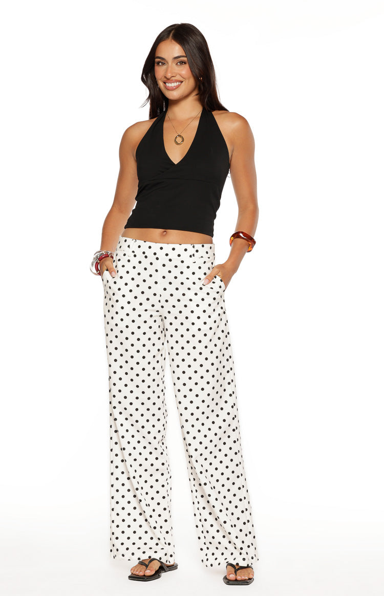 Front view of white low waist wide-leg pants with black polka dots and visible side pockets