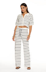 Front view of white knit wide-leg pants with navy horizontal stripes and a black drawstring waist