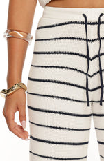 Close-up of the waffle knit texture on white pants with navy stripes and a navy drawstring waist