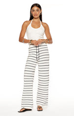 Full length view of white knit pants with horizontal navy stripes, wide-leg silhouette, and drawstring waist
