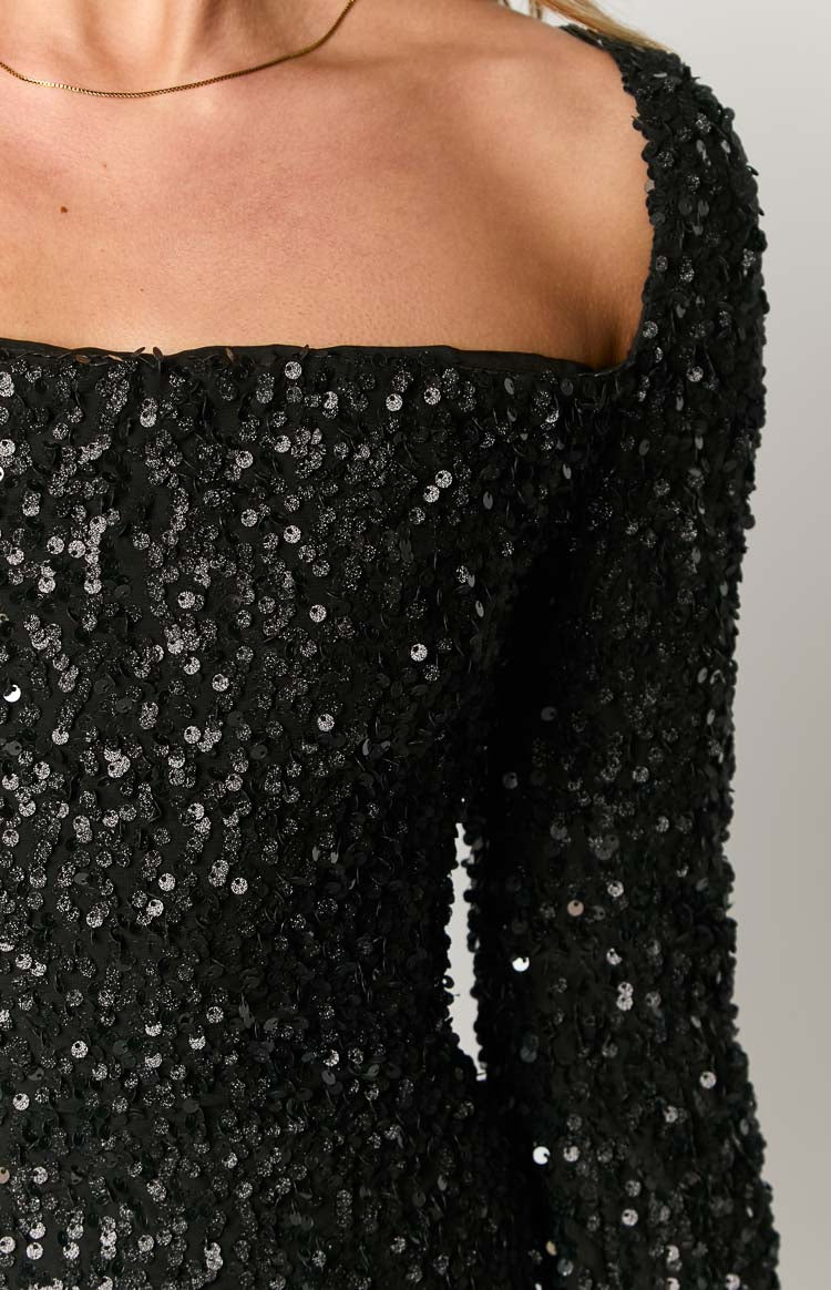 Close-up of the black sequin square neckline and the long sleeve of the mini dress