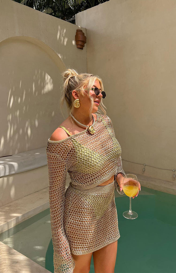 Beginning Boutique Wild Thoughts Gold Metallic Fishnet Mini Skirt gold metallic fishnet knit mini skirt with a thick waistband