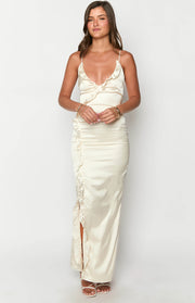 Cream satin maxi dress with a ruffled V-neck, thin spaghetti straps, and ruched side detail with a high slit