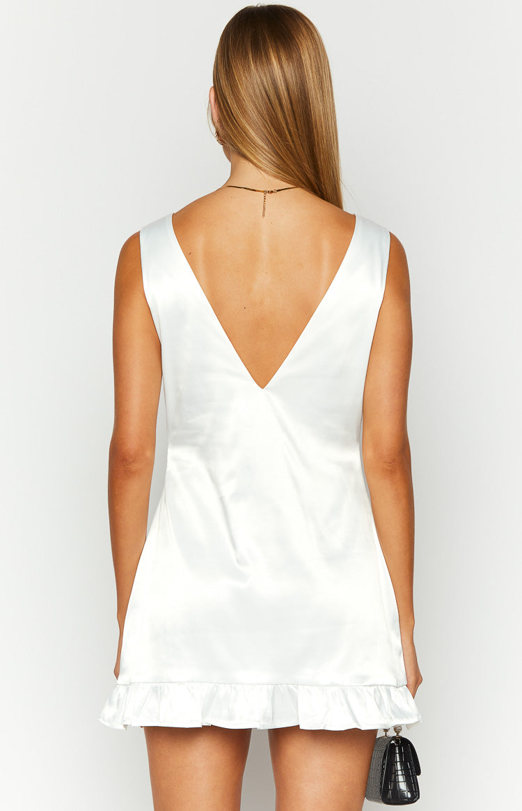 Rear view of a white satin mini dress with a deep V-neck back and ruffled hem