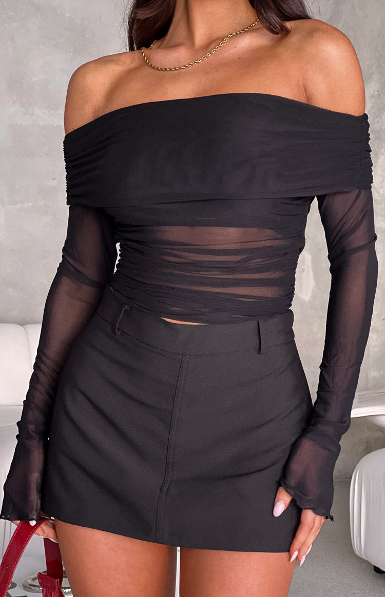 Close-up of a black mini skort featuring a tailored flat front and a subtle vertical seam