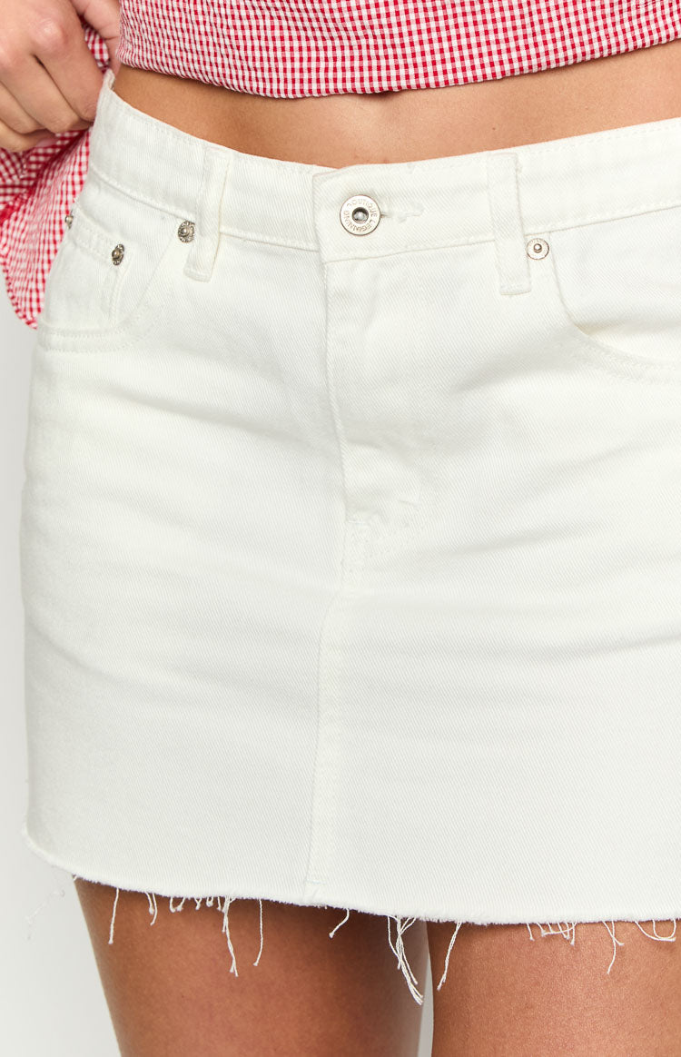 Front view of the white denim mini skirt with silver button closure and frayed raw hem