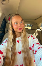 Crew neck white chunky knit jumper with red heart pattern on chest and sleeves