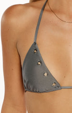 Close-up of a grey bikini top triangle cup with four silver eyelets