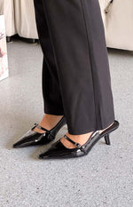 Black patent pointed toe mule heels with a Mary Jane strap and buckle detail