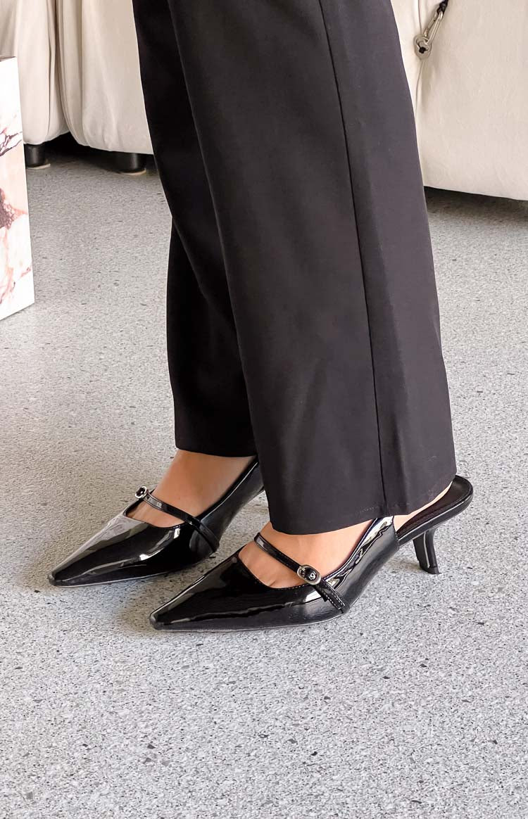 Black patent pointed toe mule heels with a Mary Jane strap and buckle detail