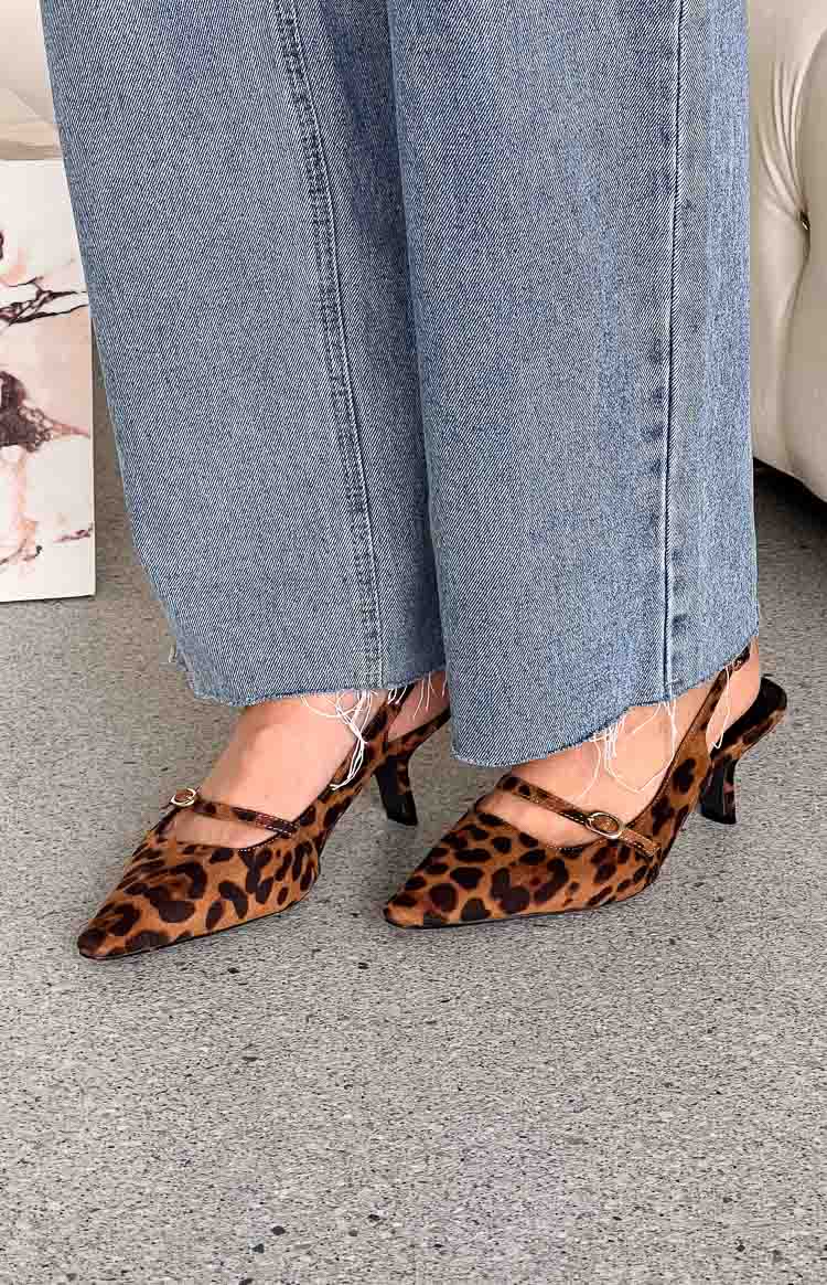 Leopard print pointed toe heels with a slingback and a buckled strap across the foot