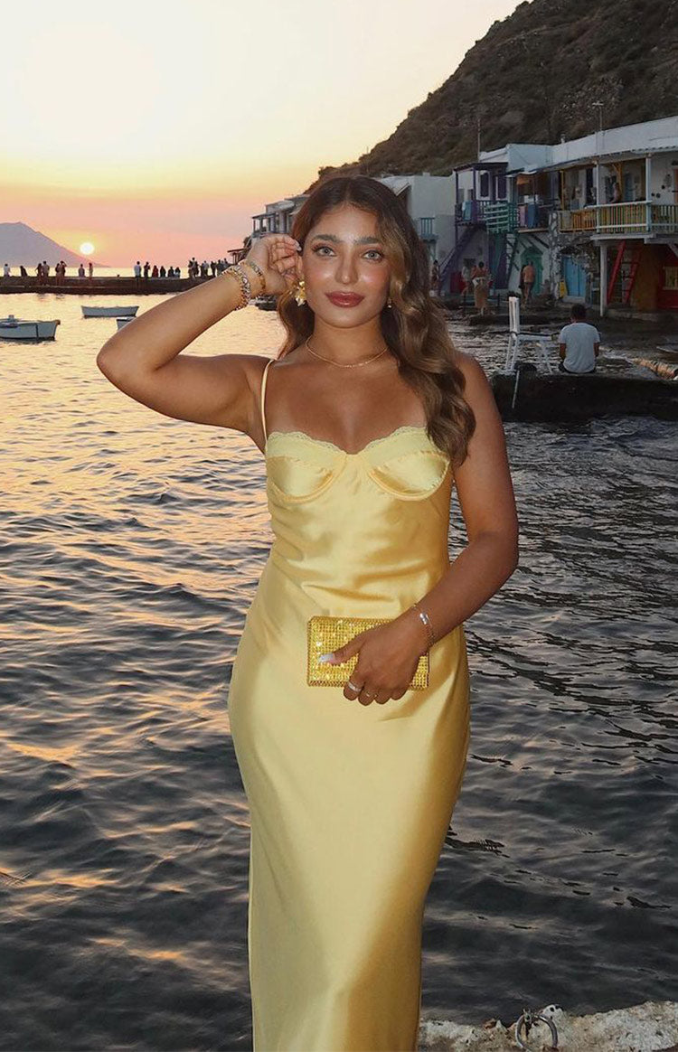 Full length view of a yellow satin midi dress with a lace-trimmed sweetheart neckline and thin spaghetti straps