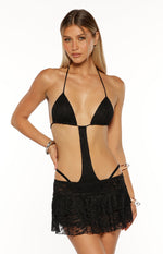 Black lace halter neck mini dress with triangle bikini top, central cut-out, and tiered skirt