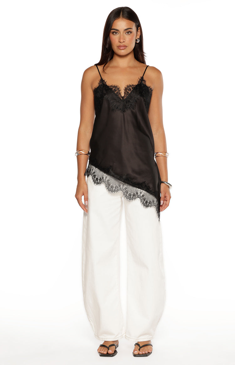 Black satin top with a deep V-neckline, thin spaghetti straps, and an asymmetrical lace-trimmed hem