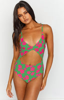Close-up of the green one-piece swimsuit with pink floral print, knotted bust detail, and front cutout