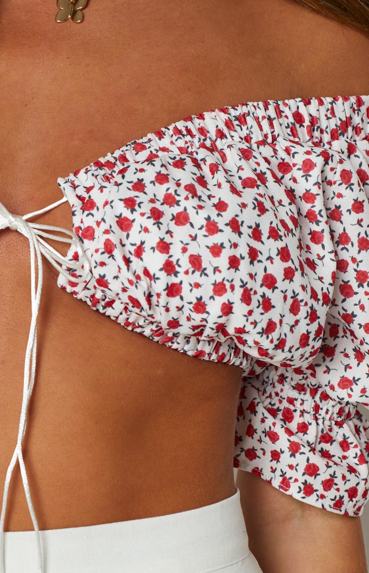 Close-up of the white floral crop top's ruched off-shoulder sleeve and white drawstring ties