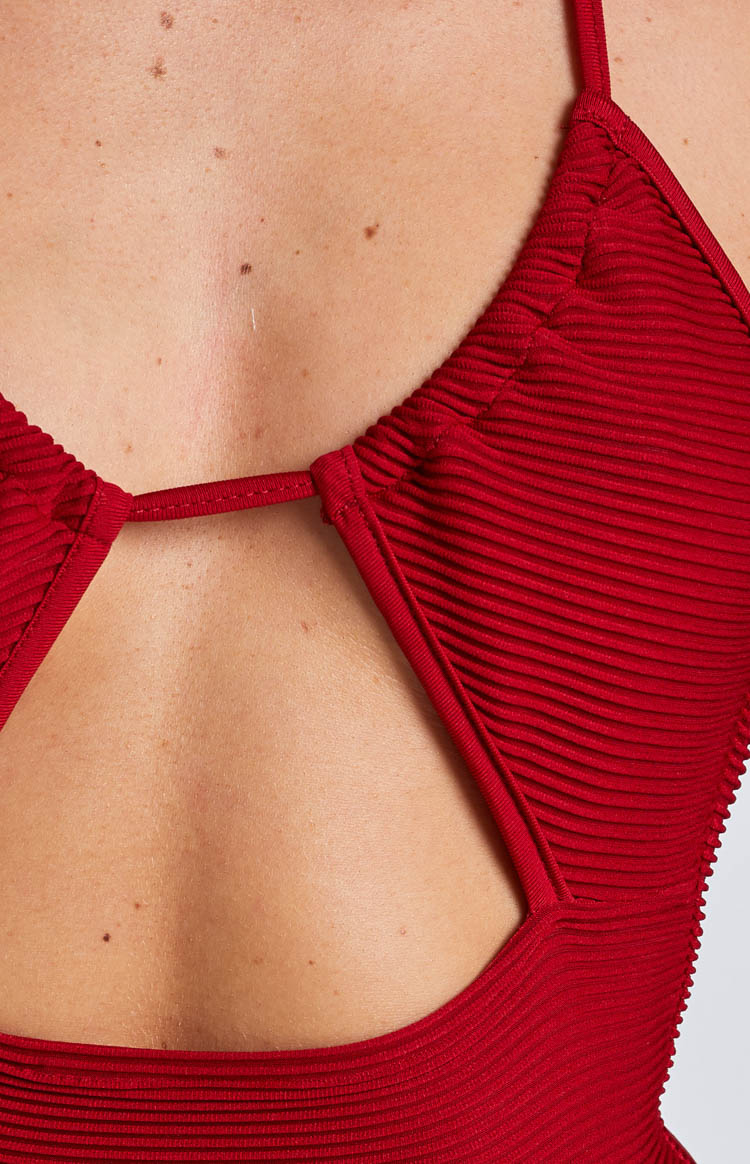 Close-up of the back cutout detail on a red ribbed mini dress with a thin connecting strap