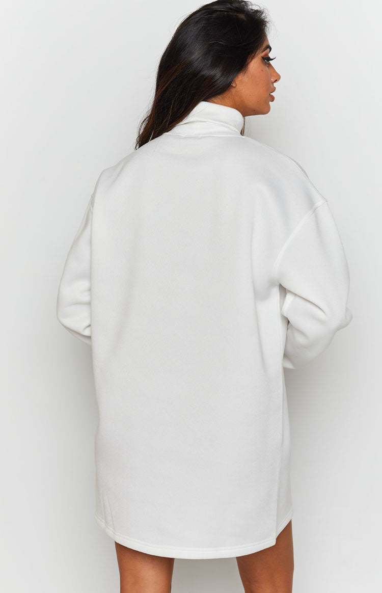 White turtleneck oversized mini dress with long sleeves and a curved back hem