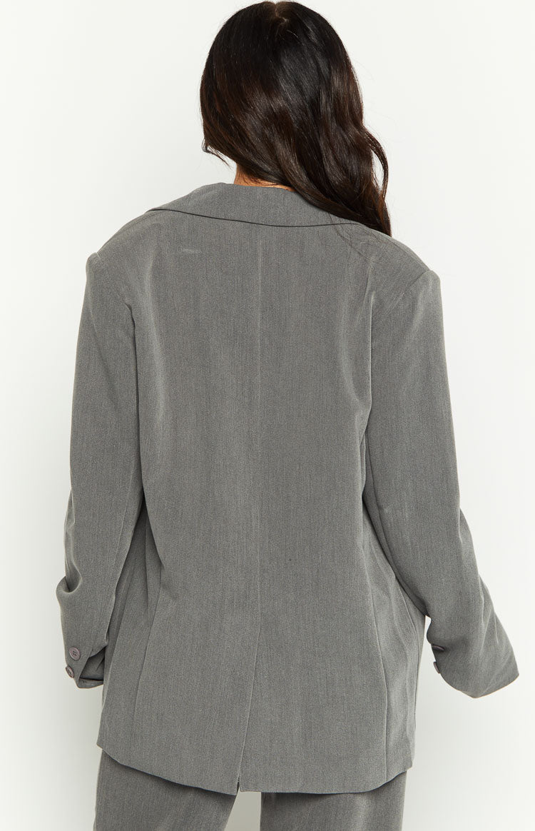 Back view of an oversized grey blazer with a notched lapel collar and a single vent at the back hem