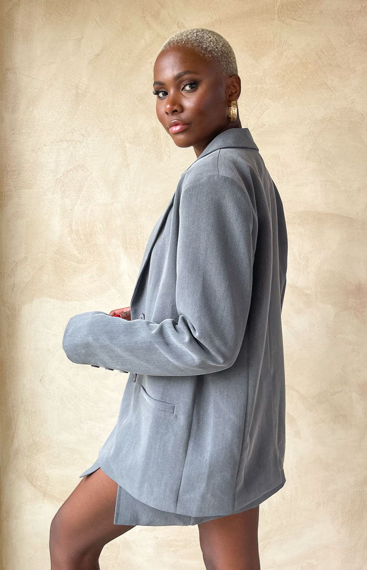 Side view of a grey oversized blazer with a soft, longline drape and notched lapels