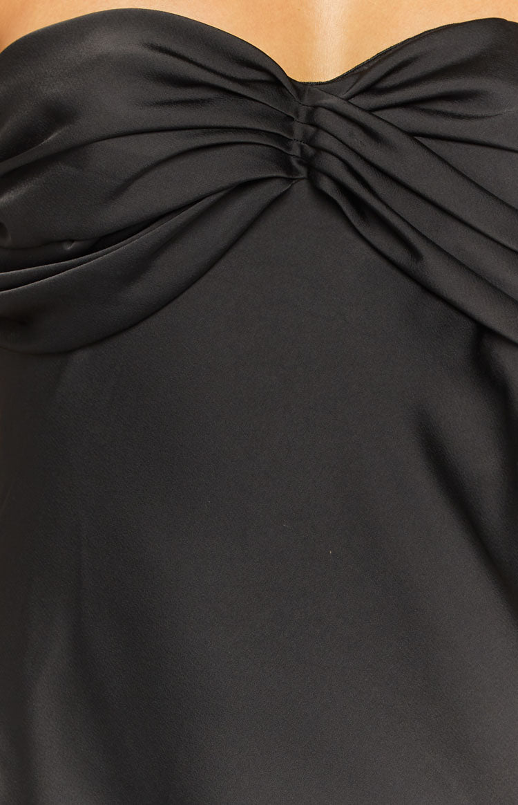 Close-up of the twisted ruched detail on the black satin dress bodice
