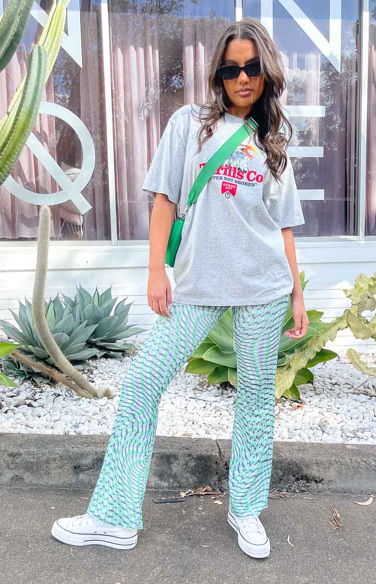 Green mesh mid-rise pants with a wavy green and lilac pattern and flared leg