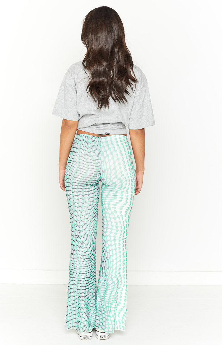Back view of the green and white optical dot mesh pants, showing the mid-rise waist and flared silhouette