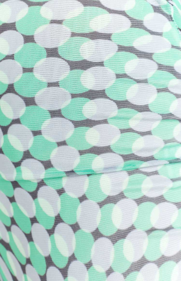 Close-up of the ruched green and white oval pattern on dark grey mesh fabric