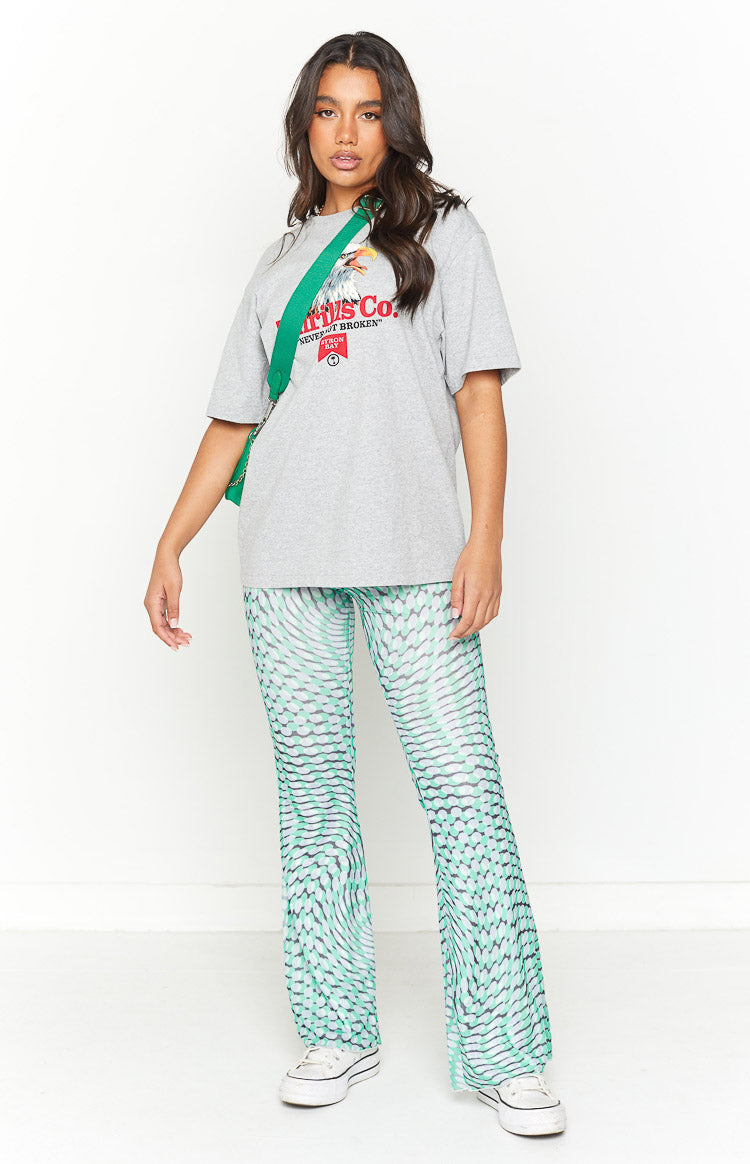 Full length view of green mesh mid-rise pants with a wavy pattern and flared hems