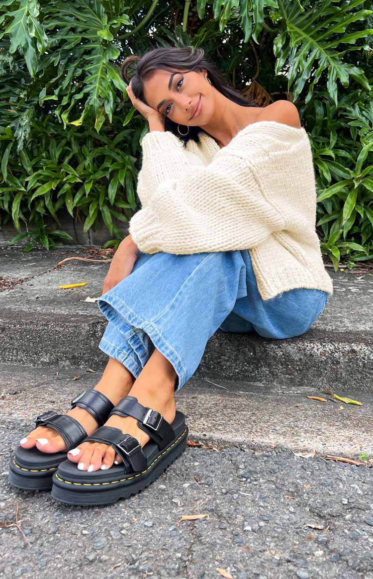 Cream chunky knit cardigan worn off-shoulder with voluminous long sleeves