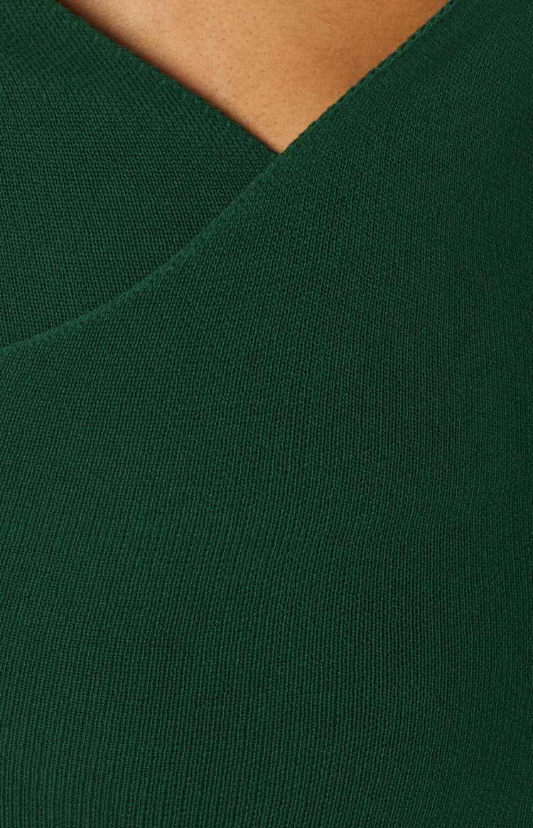 Close-up of the emerald green ribbed knit fabric and wrap detail of the midi dress