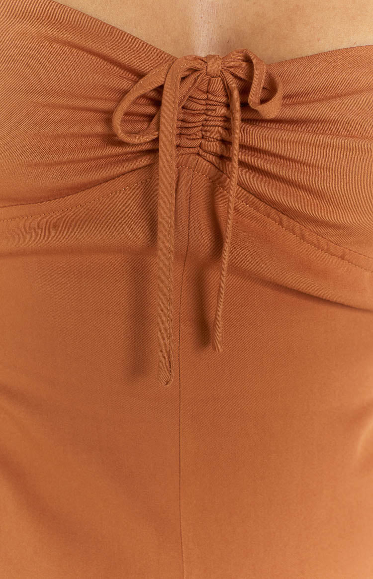 Detail shot of the brown playsuit's bust with a central drawstring tie creating ruched fabric