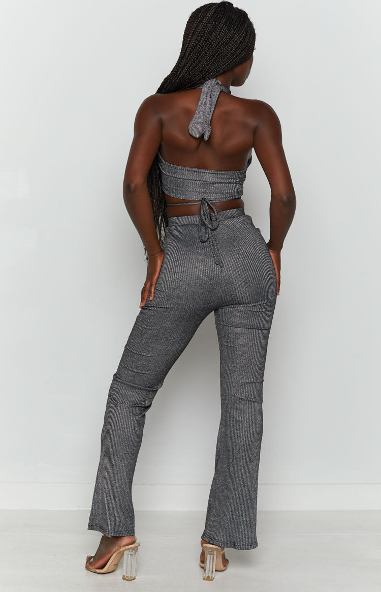 Shimmery black ribbed pants with a subtle flare hem, paired with a matching tie-back halter crop top