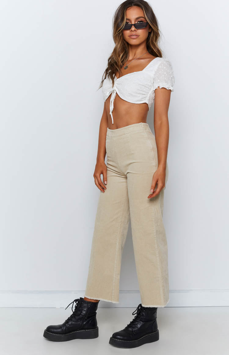 Beige corduroy wide-leg pants with a high waist and raw frayed hem