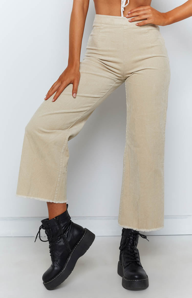 Beige corduroy wide-leg pants with a high waist and frayed cropped hem