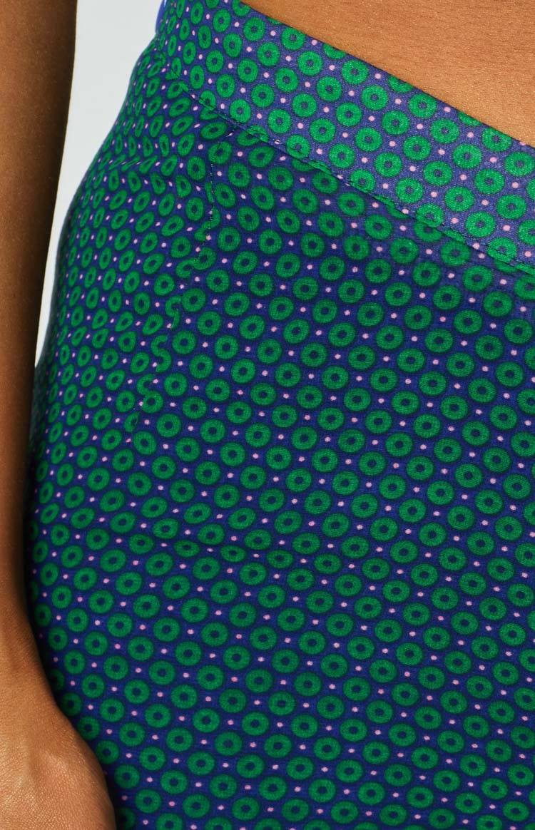 Close-up of the dark blue pants with a repeating pattern of green circles and small pink dots