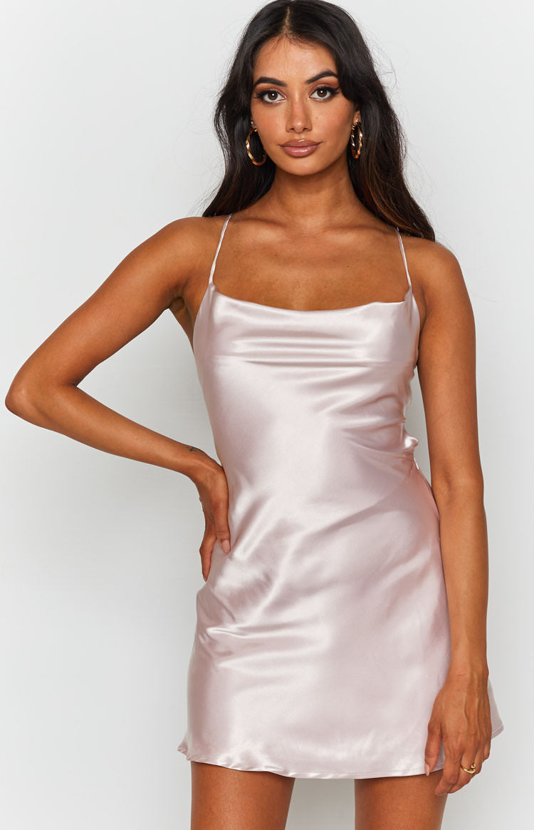 Sleek blush satin mini dress featuring a draped cowl neckline and delicate spaghetti straps