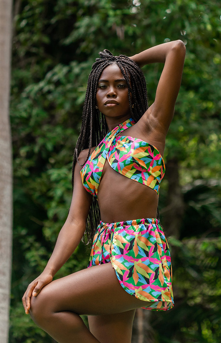 Front view of vibrant tropical leaf print wrap shorts with an elasticated waist and curved hem