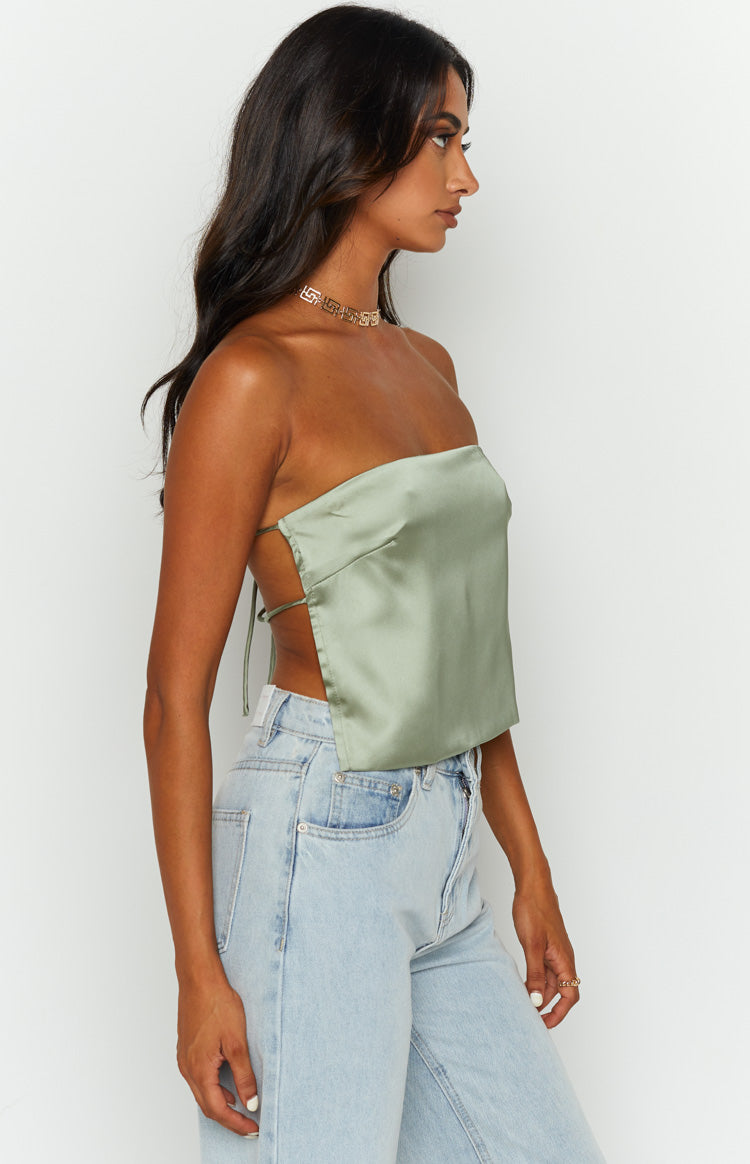 Side view of an olive satin strapless top showing the open back with thin crisscross tie straps