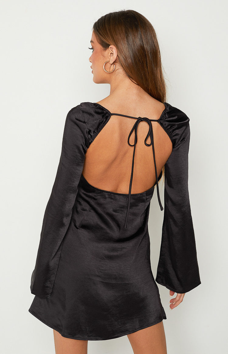 Rear view of a black satin mini dress with an open tie-back, ruched neckline, and long flared sleeves
