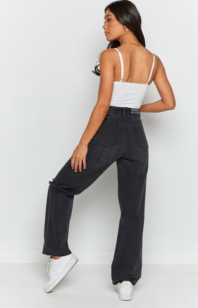 High waisted black wash wide leg jeans with distressed detail on the thigh and V-shaped back yoke